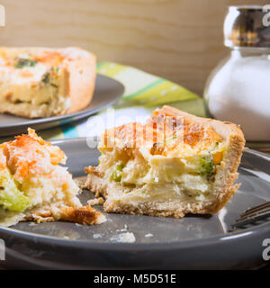 Klassische Lachs und Broccoli Quiche aus mürbteig Gebäck mit Brokkoliröschen und geräuchertem Lachs in einer cremigen freie Strecke Eierstich Stockfoto