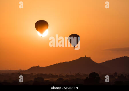 Ballon Silhouetten vor der Sonne über die alten Tempel in Bagan bei Sonnenaufgang, Myanmar Stockfoto