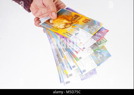 Weibliche Hand, die Banknoten in Schweizer Franken Stockfoto