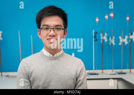 Eine intelligente jungen asiatischen Schüler sitzt in der Science Lab der Hochschule Stockfoto