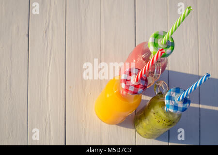 Hohe Betrachtungswinkel von frischen Orangen, Kiwi und Cherry Säfte und Smoothies auf Tisch Stockfoto