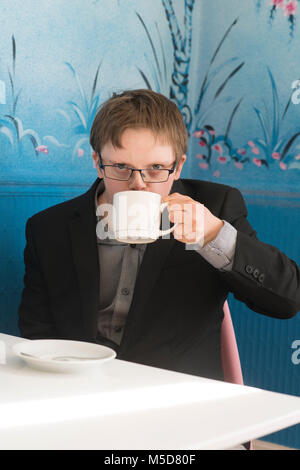 Eine junge glücklich und zuversichtlich, dass Menschen mit Down-Syndrom an einem Tisch in einem Cafe sitzt Stockfoto