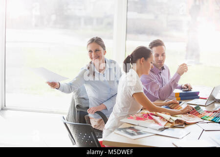 Junge Geschäftsfrau, Dokument mit den Kollegen am Schreibtisch arbeiten in kreativen Büro Stockfoto