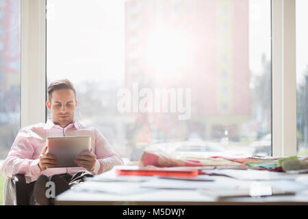 Junge Unternehmer mit digitalen Tablet am Konferenztisch in der kreativen Büro Stockfoto