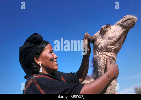 Niger, Talak in der Nähe von Agadez. Sahara. Die Berge. Sahel. Volk der Tuareg Stamm. Frau und junge Kamel. Stockfoto