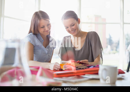 Junge Unternehmerinnen diskutieren über Fabric swatches im Büro Stockfoto