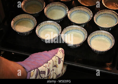 Teig in Formen für die Muffins im Ofen Stockfoto