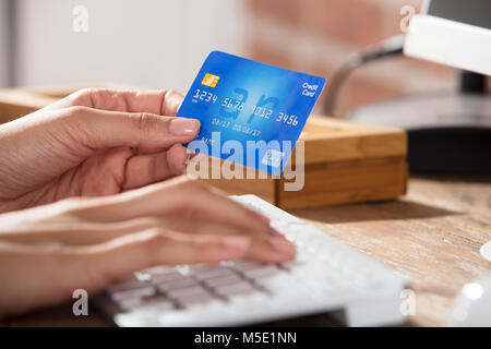 Nahaufnahme von einer Person die Hand auf Tastatur Holding Kreditkarte für die Bezahlung Online Stockfoto