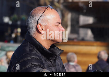 Kopf und Schultern Profil eines Mannes auf dem Trafalgar Square genießen Sie die Wintersonne mit seiner Brille auf seinem Kopf gehockt Stockfoto