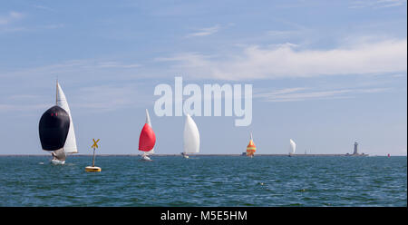 Eine Flotte von klassischen Rennyachten Segel downwind unter bunten Spinnaker an einem sonnigen Tag. Stockfoto