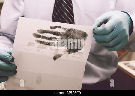 Die Forscher nehmen Fingerabdrücke von der Verdächtige in der Kriminalität. Die Untersuchung ist ein Verbrechen. Kriminalität. Stockfoto