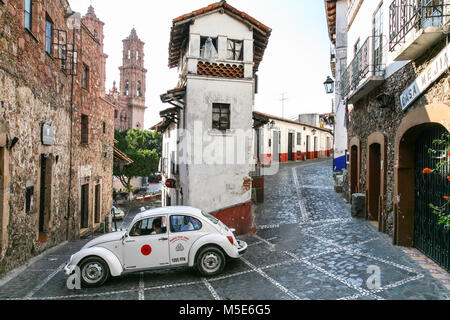 TAXCO, MEXIKO - 3. März 2012: Taxi VW Käfer im Zentrum von Taxco Bewegen auf dem schmalen Central Street in der Nähe des Zocalo in Taxco de Alarcon, Mexiko Stockfoto