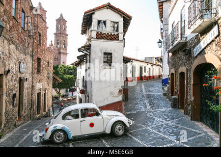 TAXCO, MEXIKO - 3. März 2012: Taxi VW Käfer im Zentrum von Taxco Bewegen auf dem schmalen Central Street in der Nähe des Zocalo in Taxco de Alarcon, Mexiko Stockfoto