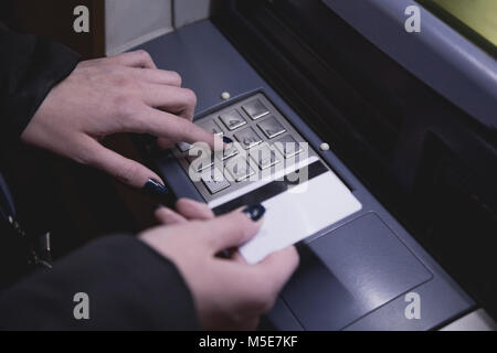 In der Nähe der weiblichen Hand, die ATM-Karten und die Eingabe security code Stockfoto