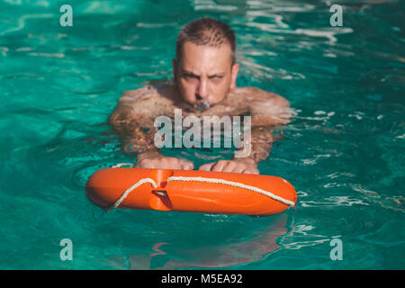 Schwimmer mit Rettungsring in Wasser. Lebensrettende Konzept Stockfoto