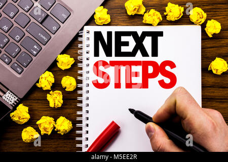 Konzeptionelle Hand schreiben Bildunterschrift die nächsten Schritte. Business Konzept für die künftige Golas und Ziel auf Tablet Notebook geschrieben, Holz- hintergrund Geschäftsmann Stockfoto