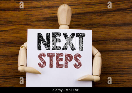 Konzeptionelle Hand schreiben Bildunterschrift inspiration Nächste Schritte angezeigt. Business Konzept für die künftige Golas und Ziel auf haftnotiz Papier auf Holz Stockfoto