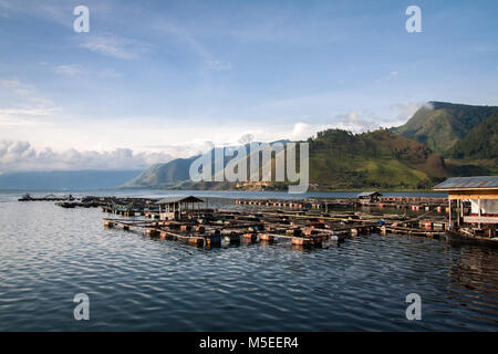 Kleinen indonesischen Fischfarm am Ufer des riesigen Lake Toba in Nordsumatra. Eine schöne und idyllische Landschaft Bild mit umliegenden grünen Berge Stockfoto