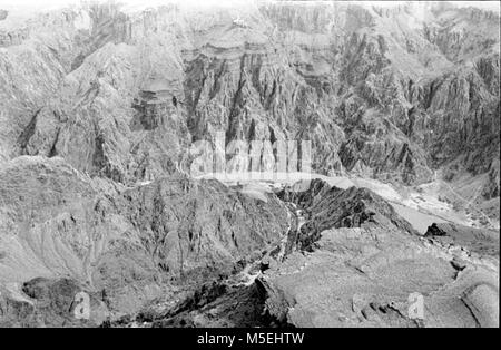 Grand Canyon Historischen - Luftbild der Phantom Ranch Bereich 'Silver Brücke" gebaut ÜBER DEN COLORADO RIVER FÜR DIE DURCHFÜHRUNG DER TRANSCANYON WASSERLINIE. PHANTOM RANCH, wo Wasser DIENSTLEISTUNGEN CONCESSIONER EINRICHTUNGEN & PARK STRUKTUREN MÜSSEN ÜBER 2 DRUCKREGLER AUF NUTZBARE innenpolitischen Druck zu verringern. Der statische Druck Ansätze 1000 PSI IN DER Phantom Ranch. CIRCA 1980. Stockfoto