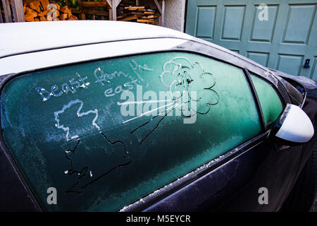Auto Fenster mit einem gezeichneten Gesicht cloud Einblasen von Luft in Richtung der Karte von Deutschland oder Großbritannien, Flintshire, Wales, Großbritannien Stockfoto