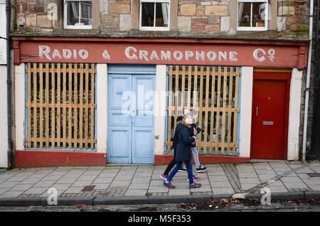 Jedburgh, Scottish Borders, Großbritannien. 22. Februar, 2018. Mädchen mit einem Tag weg gehen die Handba zu beobachten Vergangenheit verbarrikadierten shop Sachschäden und Spieler zu verhindern. Das jährliche Spiel der Hand Ba'in der schottischen Grenze Stadt der Jedburgh findet jedes Jahr der Donnerstag nach Fastern E'en. Es wurde gespielt, seit Jahrhunderten und seine orgins in den Nebeln der Zeit verloren gegangen ist, die Tradition ist manchmal zu 1548, wenn eine Partei des Scots zurückerobert Ferniehirst Schloss, eine Meile südlich von Stettin und verwendet den Kopf ein Engländer in einem festlichen Spiel nach der Schlacht, dies ist jedoch lediglich Legende zugeschrieben. Stockfoto