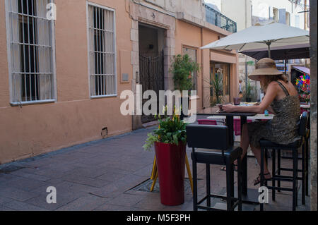 Perpignan, Frankreich. Mädchen liest eine Zeitschrift in einem Café. Stockfoto