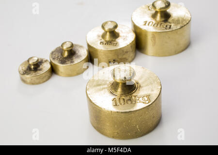 Sammlung von Dir Vintage Goldenen und Silbernen Kalibriergewichte auf weißem Hintergrund Stockfoto