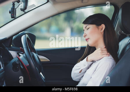 Asiatische Geschäftsfrau Schmerzen auf ihre Schulter und den Hals während der Fahrt Stockfoto