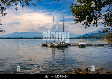 Zwei Jachten vertäut am kleinen hölzernen Pier unter dem schönen Himmel auf See Viverone in Piemont, Norditalien. Stockfoto