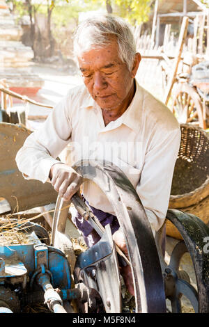 Bagan, Myanmar, 27. Dezember 2017: Alter Mann schleift die Messer einer Erntemaschine Stockfoto