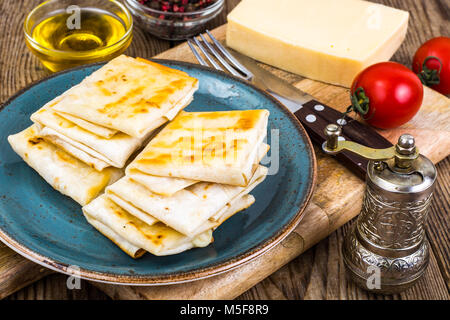 Umschläge von dünnen Armenischen Brot lavash gebraten mit knuspriger Kruste. Füllung aus Käse, Tomaten und grünen für ein warmes Frühstück. Studio Foto Stockfoto
