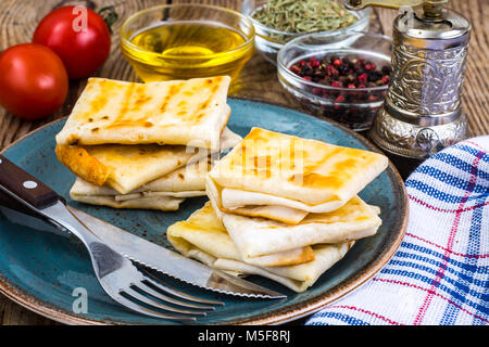 Umschläge von dünnen Armenischen Brot lavash gebraten mit knuspriger Kruste. Füllung aus Käse, Tomaten und grünen für ein warmes Frühstück. Studio Foto Stockfoto
