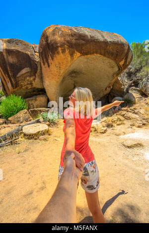 Folgen Sie mir, Frau, Hände halten in Hippo's Yawn, ein Hippo-geformten Felsen in der Nähe der Wave Rock in Hyden, australische Outback, Western Australia. Konzept der Reise der touristischen Reisenden, der Mann mit der Hand. Stockfoto