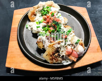 Kartoffelpuffer, saure Sahne, Speck, Grüns. Studio Foto Stockfoto