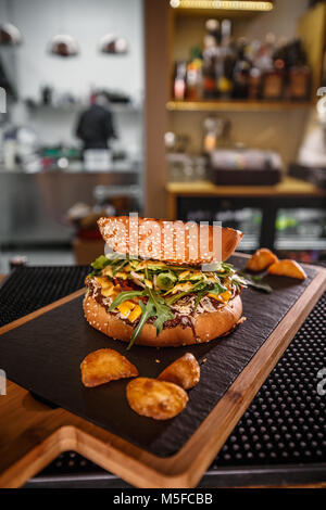 Köstliche zog Beef Burger mit Kartoffelecken auf fancy Board Stockfoto