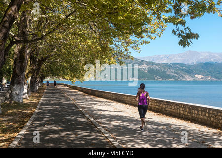 Ein Jogger am Ufer des Sees Pamvotidha in Ioannina, Epirus, in Nordgriechenland. Stockfoto