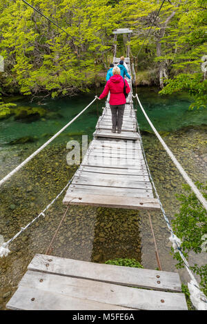 Trekker kreuze Fußgängerbrücke über Rio del Vuetas; Lago del Desierto; in der Nähe von Reserva Provincial Lago del Desierto, Patagonien, Argentinien Stockfoto