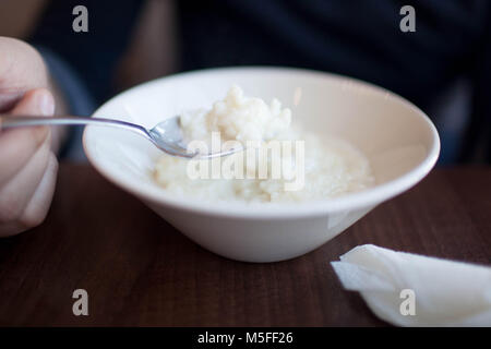 Brei Hafer Müsli mit Blaubeeren und einer Flasche Milch auf Vintage White Holztisch. Gesundes Essen, gesundes Frühstück essen Stockfoto
