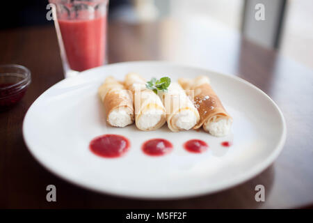 Pfannkuchen serviert mit Erdbeeren, Erdbeermarmelade und Schlagsahne. Nahaufnahme Stockfoto