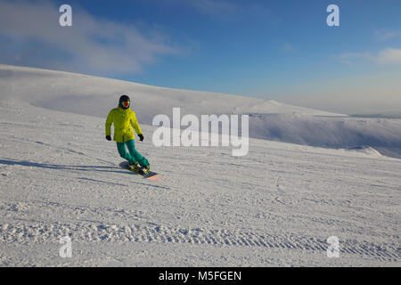 Snowboarder Reiten am Hang bei Ski Resort an einem sonnigen Tag Stockfoto