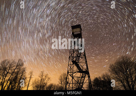 Eine verlassene Fire Tower steht gegen die dunklen Nachthimmel Silhouette als Sterne Kreis um die North Star. Stockfoto