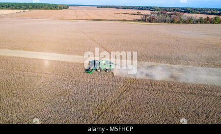 Beeindruckende Luftaufnahme von Mähdrescher fahren durch Reihen von Sojabohnen und kicking up dust, Maryland Stockfoto
