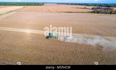 Beeindruckende Luftaufnahme von Mähdrescher fahren durch Reihen von Sojabohnen und kicking up dust, Maryland Stockfoto