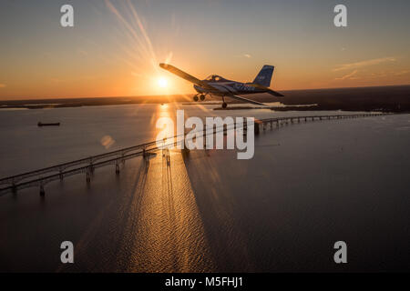 Blue Vans RV-12 Light Sport Aircraft in Richtung der untergehenden Sonne über die Chesapeake Bay Bridge, Stevensville, Maryland fliegen. Stockfoto