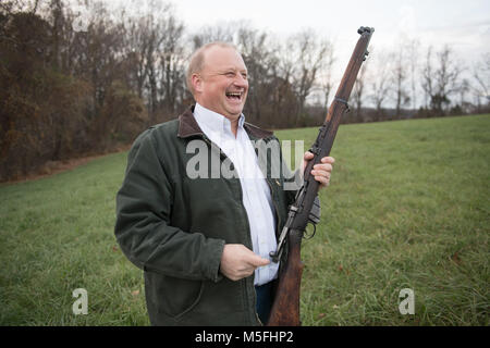 Im mittleren Alter Mann Lachen und halten auf Gewehr im Freien, Fallston, Maryland. Stockfoto