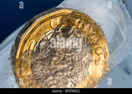 Gefrorene Neue Britische Pfund Sterling coin Nahaufnahme Makro innerhalb von Eiswürfeln. Stockfoto