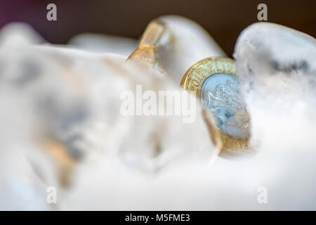 Gefrorene Neue Britische Pfund Sterling coin Nahaufnahme Makro innerhalb von Eiswürfeln. Stockfoto