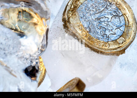 Gefrorene Neue Britische Pfund Sterling coin Nahaufnahme Makro innerhalb von Eiswürfeln. Stockfoto