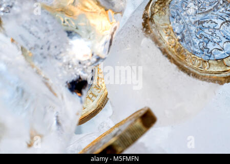 Gefrorene Neue Britische Pfund Sterling coin Nahaufnahme Makro innerhalb von Eiswürfeln. Stockfoto