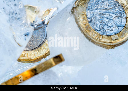 Gefrorene Neue Britische Pfund Sterling coin Nahaufnahme Makro innerhalb von Eiswürfeln. Stockfoto